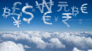 Clouds in the shape of currency symbols against a blue sky. 