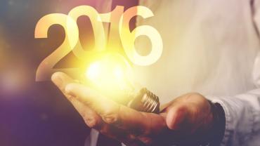 in the palm of a man's hands is a glowing lightbulb with 2016 rising above it