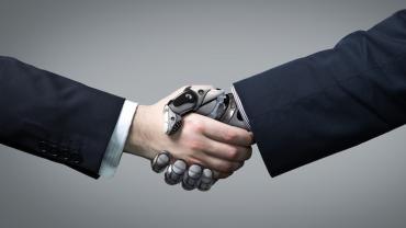 artificial intelligence: a human hand shaking a robot hand